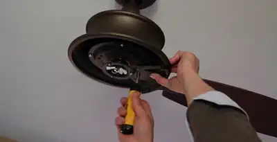 Electrician installing ceiling fan mounting bracket and fixture in Oklahoma City, OK