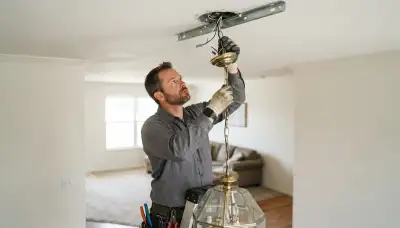 Electrician wiring a chandelier on a rated ceiling brace in an Oklahoma City, OK home