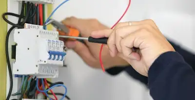 Electrician installing and adjusting circuit breakers in an electrical panel in Oklahoma City, OK