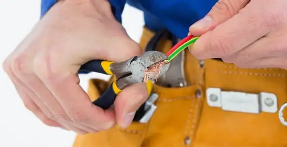 licensed electrician securing electrical wiring with professional tools during service work in Oklahoma City, OK