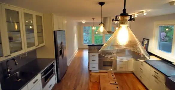 Residential electrician installing modern indoor light fixture in a home in Oklahoma City, OK