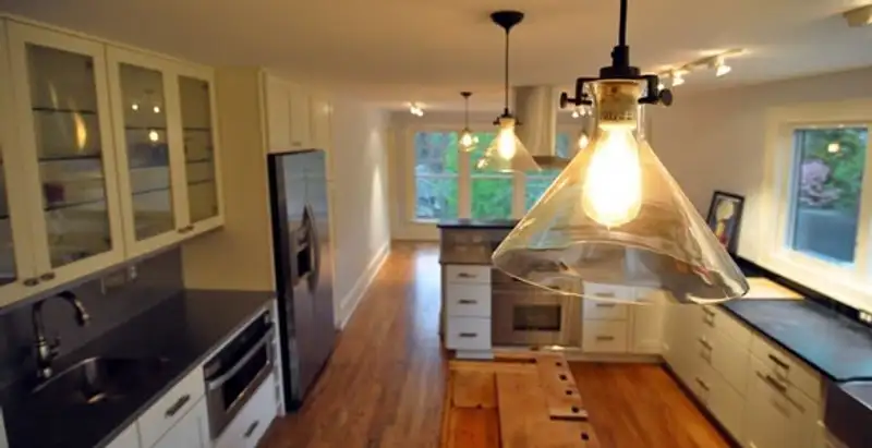 Residential electrician installing modern indoor light fixture in a home in Oklahoma City, OK