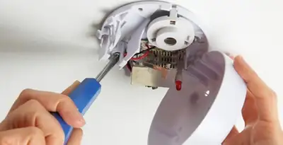 Certified technician wiring smoke detector during installation in Oklahoma City, OK